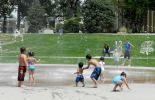 Children playing in water fountain